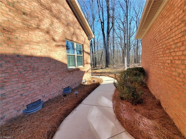 view of side of home featuring brick siding and crawl space