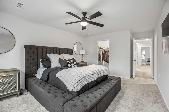 carpeted bedroom with a spacious closet, a closet, and ceiling fan