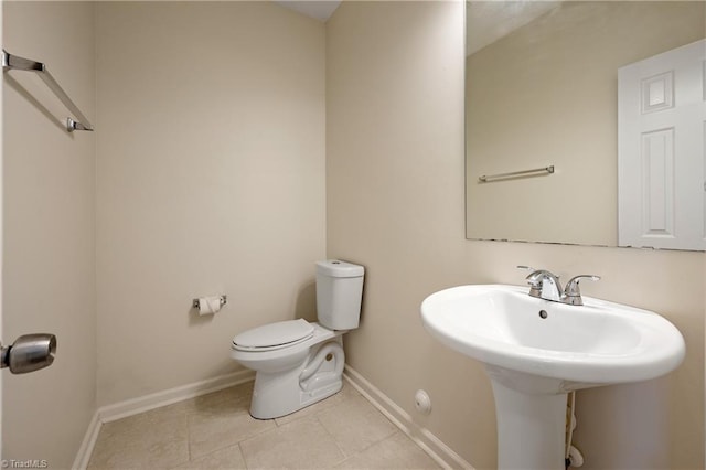 825 Central Park Ave, Greensboro, NC 27407 - half bathroom with tile patterned floors, toilet, baseboards, and a sink