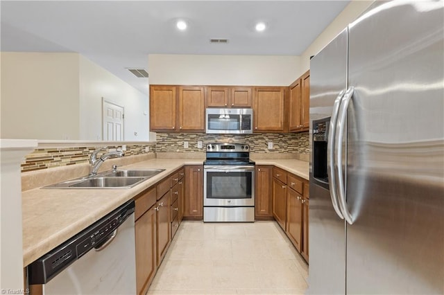 825 Central Park Ave, Greensboro, NC 27407 - kitchen featuring stainless steel appliances, a sink, brown cabinets, decorative backsplash, and recessed lighting