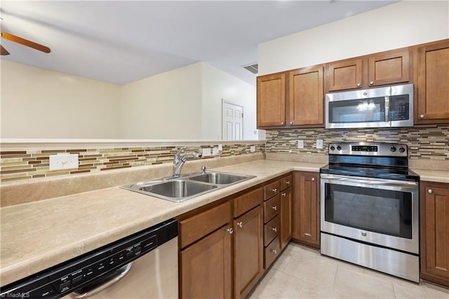 825 Central Park Ave, Greensboro, NC 27407 - kitchen with stainless steel appliances, ceiling fan, a sink, decorative backsplash, and light tile patterned floors