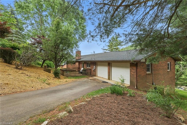 174 Sunny Knoll Ln, Boone, NC 28607 - view of front of house featuring a chimney, asphalt driveway, brick siding, and a garage