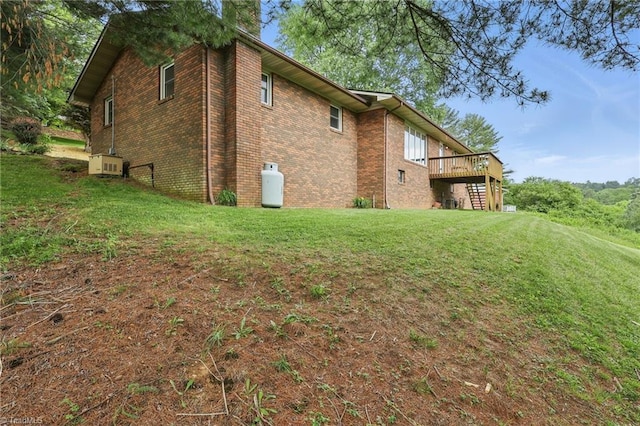 174 Sunny Knoll Ln, Boone, NC 28607 - view of side of home featuring a wooden deck, brick siding, a lawn, and a chimney