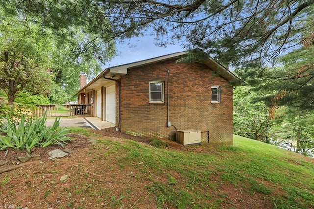 174 Sunny Knoll Ln, Boone, NC 28607 - view of side of home with a chimney, brick siding, an attached garage, and a wooden deck