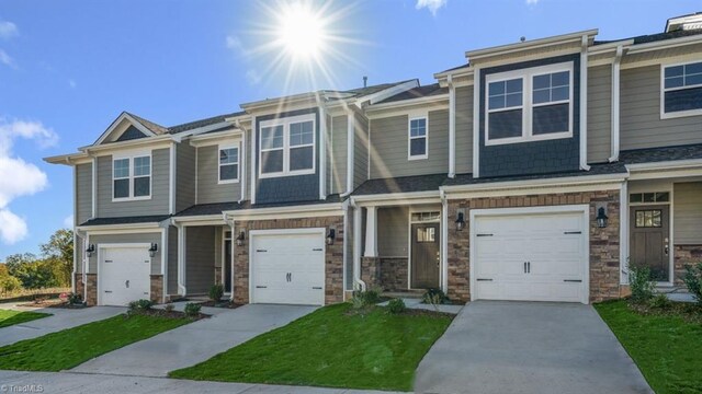1404 Amberview Ln, Kernersville, NC 27284 - townhome / multi-family property featuring a garage, stone siding, a front lawn, and concrete driveway