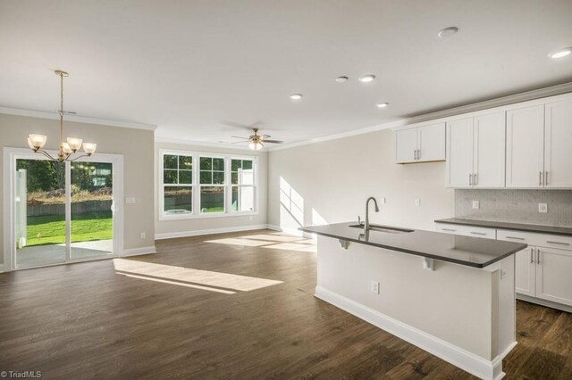 1404 Amberview Ln, Kernersville, NC 27284 - kitchen with decorative backsplash, dark countertops, a sink, and ornamental molding