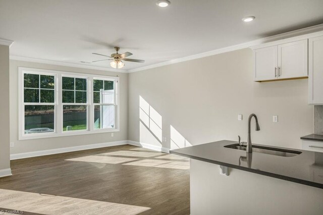 1404 Amberview Ln, Kernersville, NC 27284 - kitchen with ornamental molding, baseboards, dark countertops, and a sink