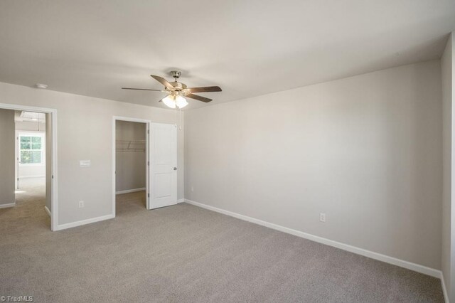 1404 Amberview Ln, Kernersville, NC 27284 - unfurnished bedroom featuring a walk in closet, baseboards, carpet flooring, and a closet