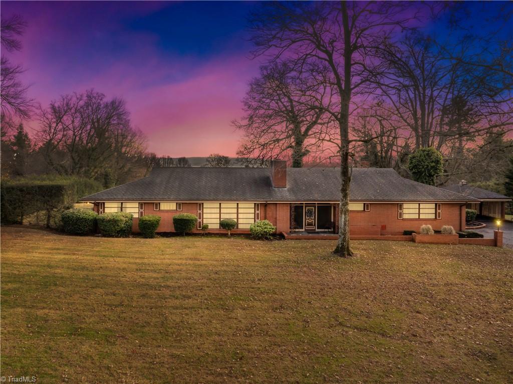 back house at dusk with a yard