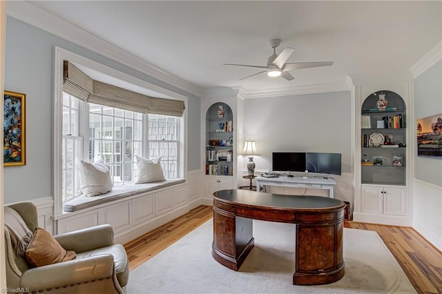 office space with light wood-type flooring, ornamental molding, and built in shelves