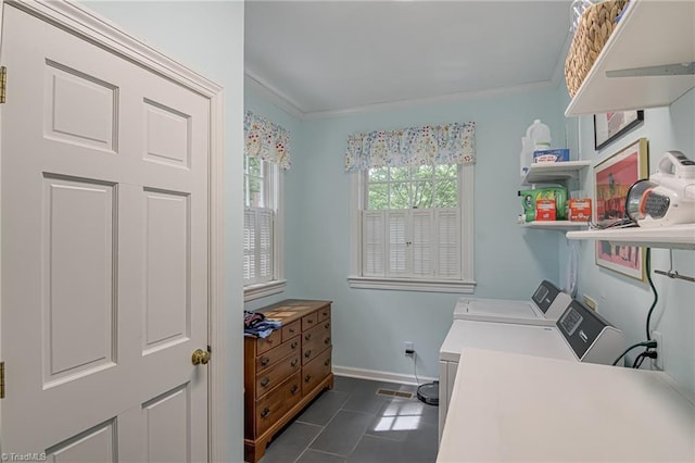 laundry area featuring laundry area, crown molding, washing machine and dryer, baseboards, and dark tile patterned floors