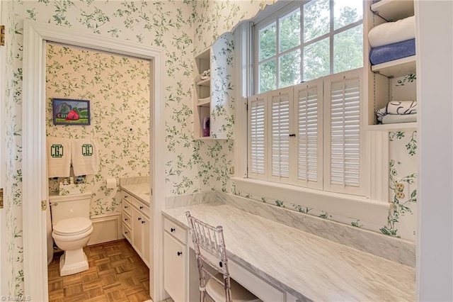 bathroom featuring toilet and wallpapered walls