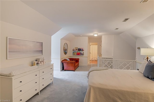 bedroom with visible vents, vaulted ceiling, and light colored carpet