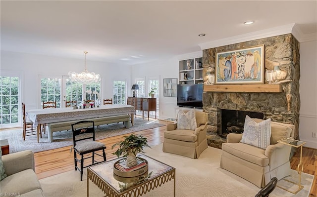 living area with an inviting chandelier, ornamental molding, wood finished floors, a fireplace, and recessed lighting