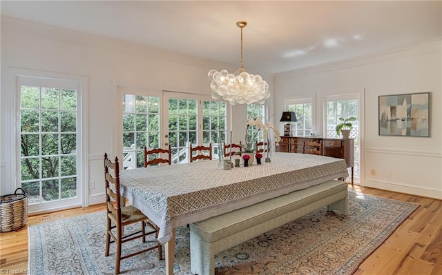 dining space featuring visible vents, ornamental molding, wood finished floors, and a chandelier