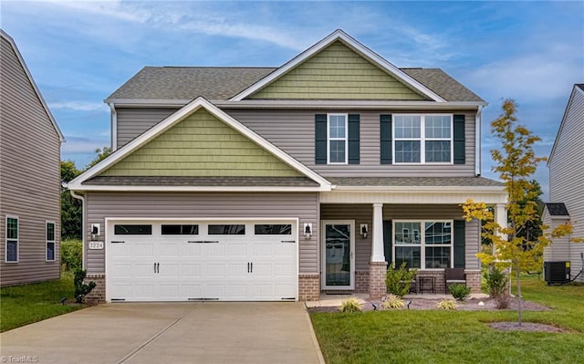 craftsman house with a garage, covered porch, central AC unit, and a front yard