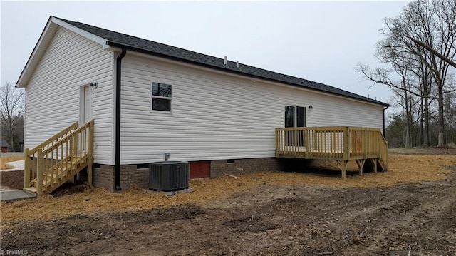 rear view of house with a wooden deck and central air condition unit