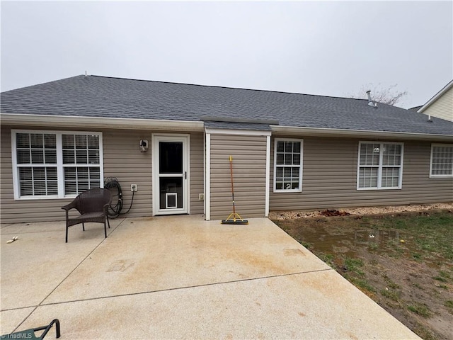 back of house with a patio and a shingled roof