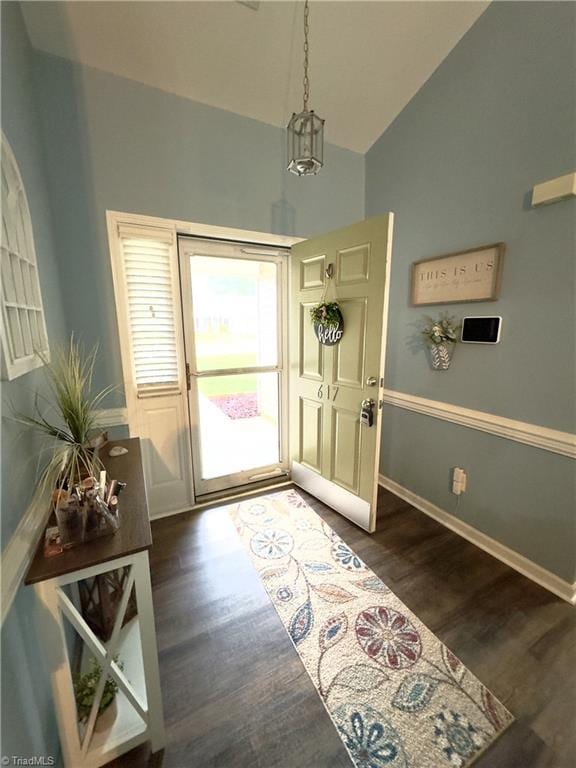 entryway featuring dark wood-style floors, vaulted ceiling, and baseboards