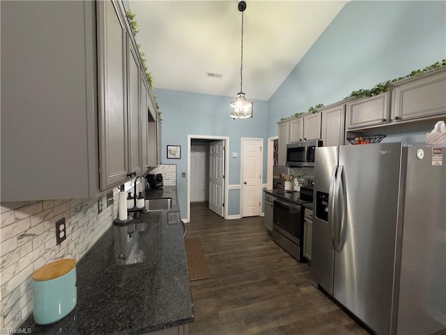 kitchen featuring stainless steel appliances, visible vents, decorative backsplash, dark wood-type flooring, and a sink