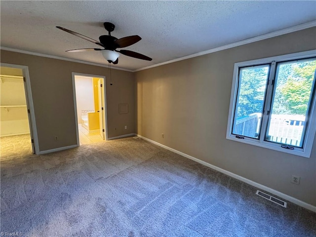 unfurnished bedroom with a closet, light colored carpet, a walk in closet, and ceiling fan