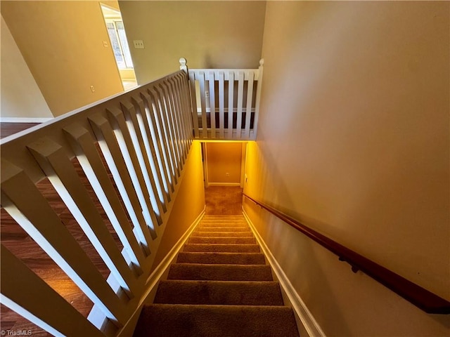 stairs with carpet floors and a towering ceiling