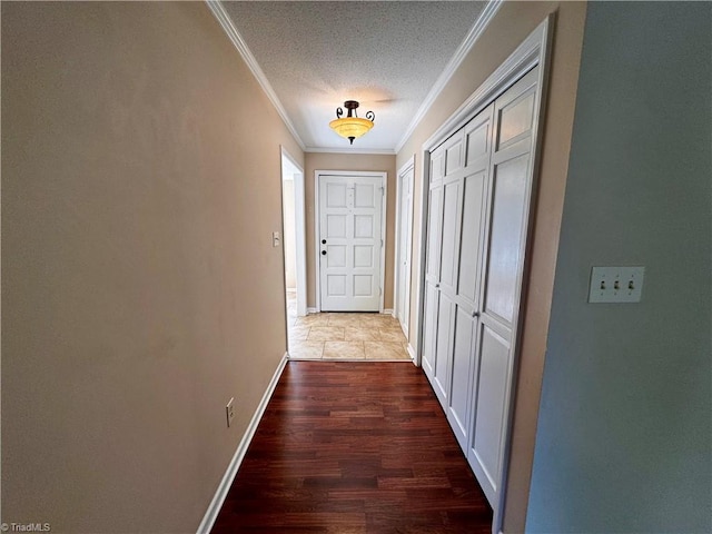 hall featuring dark wood-type flooring, crown molding, and a textured ceiling