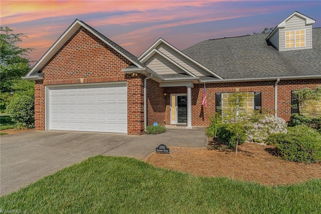 view of front of home featuring a shingled roof, an attached garage, driveway, and brick siding