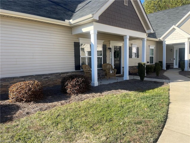 property entrance with covered porch and a yard