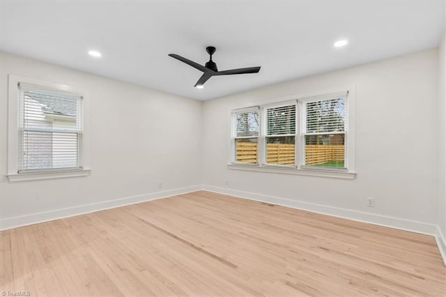 empty room with ceiling fan and light hardwood / wood-style floors