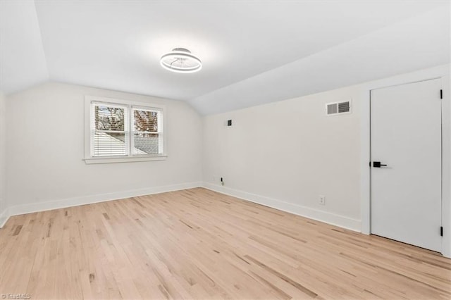 bonus room featuring lofted ceiling and light wood-type flooring