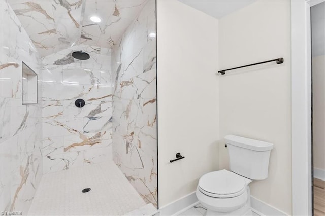 bathroom featuring tiled shower and toilet