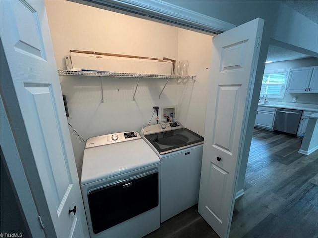 clothes washing area featuring a textured ceiling, washer and clothes dryer, dark hardwood / wood-style floors, and sink