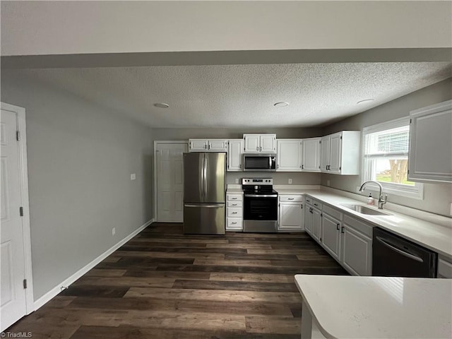 kitchen with a textured ceiling, sink, white cabinetry, appliances with stainless steel finishes, and dark hardwood / wood-style flooring