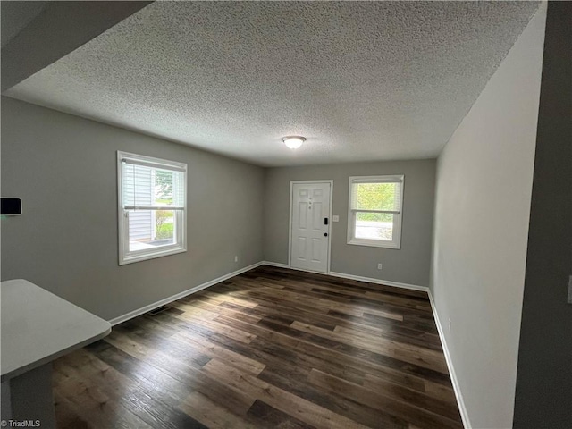 entryway with a textured ceiling and dark hardwood / wood-style flooring