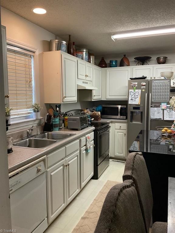 kitchen featuring sink, white cabinets, a textured ceiling, and appliances with stainless steel finishes