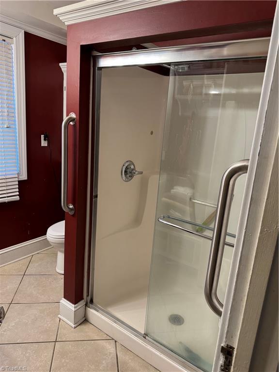 209 Abernathy St NW, Lenoir, NC 28645 - bathroom featuring tile patterned flooring, toilet, a stall shower, and baseboards