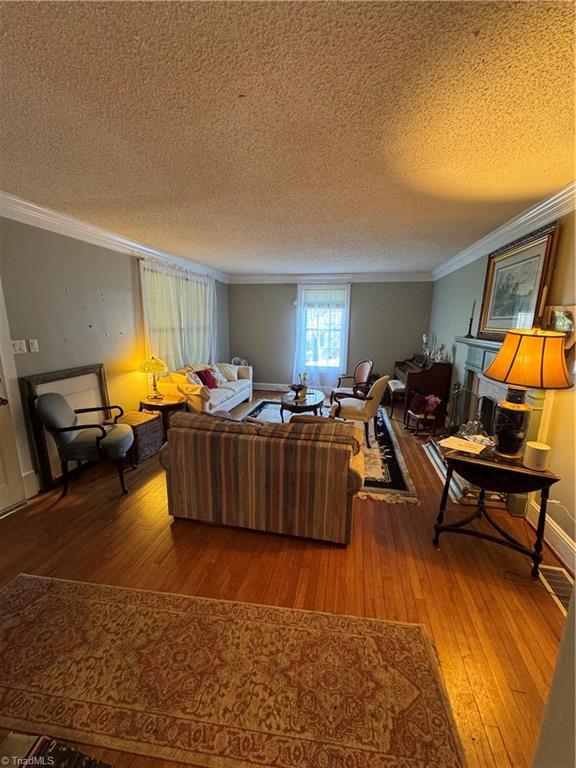 209 Abernathy St NW, Lenoir, NC 28645 - living area with a textured ceiling, ornamental molding, and hardwood / wood-style flooring