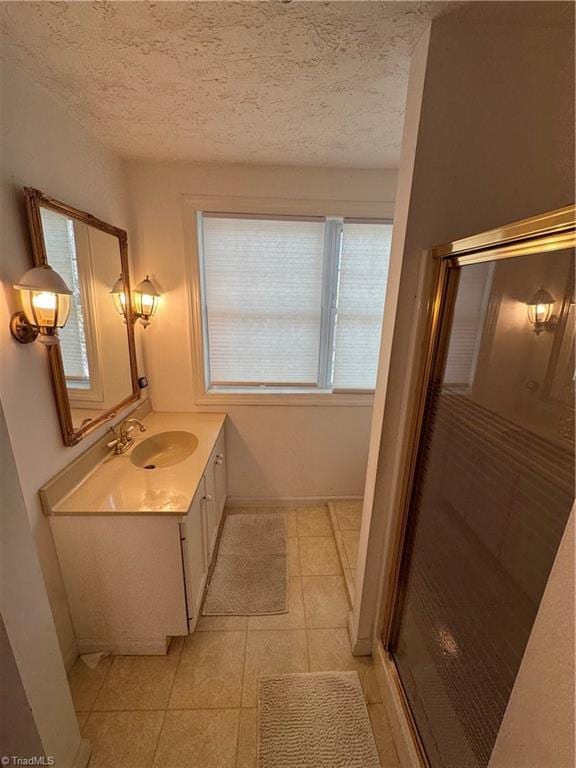 209 Abernathy St NW, Lenoir, NC 28645 - bathroom with vanity, a stall shower, a textured ceiling, and tile patterned flooring