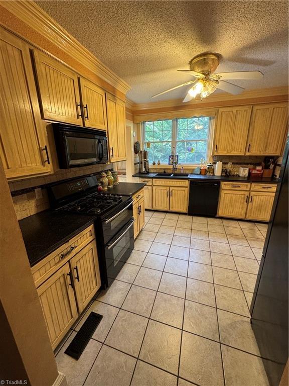 209 Abernathy St NW, Lenoir, NC 28645 - kitchen with black appliances, a sink, dark countertops, light tile patterned floors, and ceiling fan