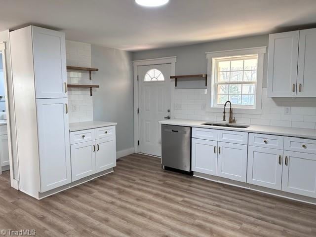 kitchen featuring open shelves, stainless steel dishwasher, a sink, and white cabinetry