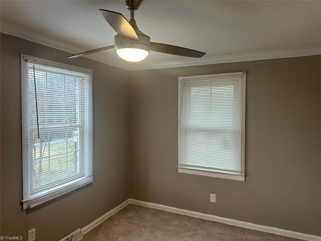 empty room with ceiling fan, plenty of natural light, carpet, and crown molding