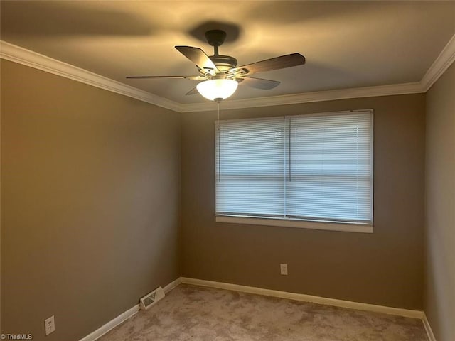 carpeted spare room with ceiling fan and ornamental molding