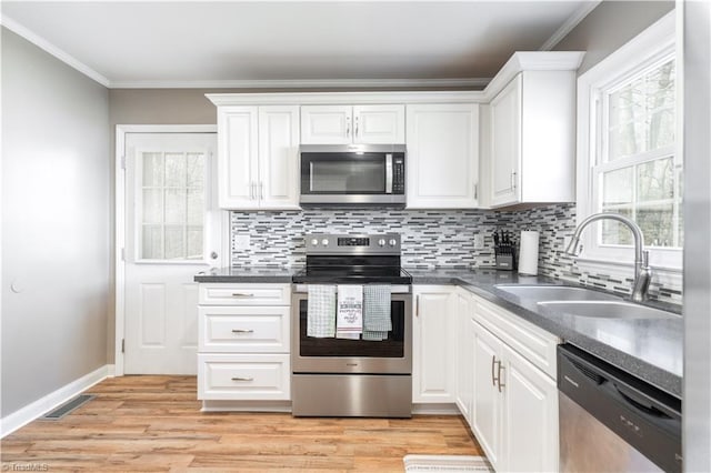 kitchen featuring crown molding, appliances with stainless steel finishes, sink, and white cabinets