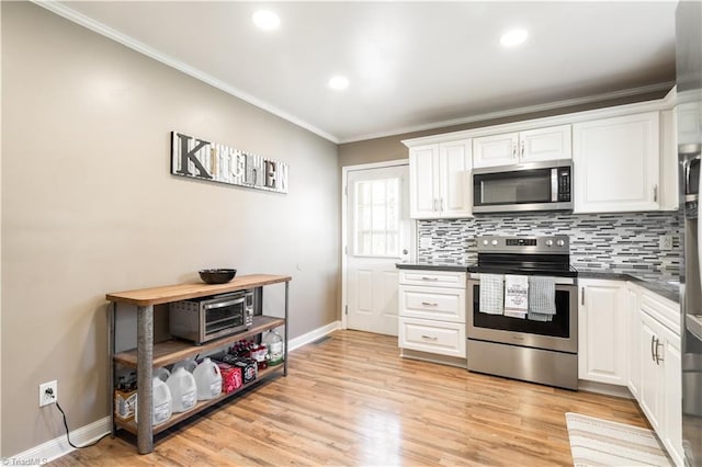 kitchen with crown molding, stainless steel appliances, and white cabinets