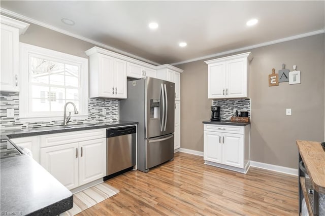 kitchen featuring white cabinetry, sink, ornamental molding, and appliances with stainless steel finishes