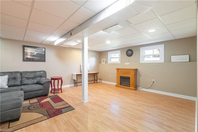 living room featuring wood-type flooring and a drop ceiling