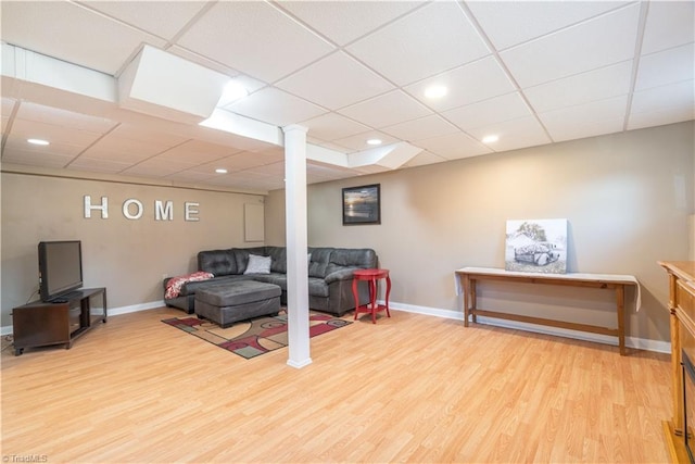 living room with a paneled ceiling and light hardwood / wood-style floors