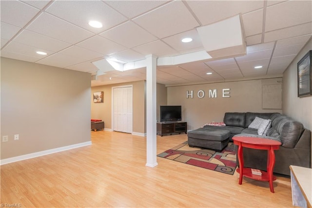 living room with wood-type flooring and a paneled ceiling