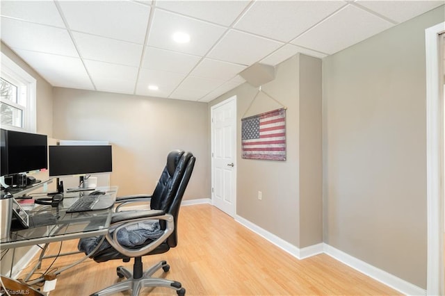 home office with a paneled ceiling and hardwood / wood-style floors